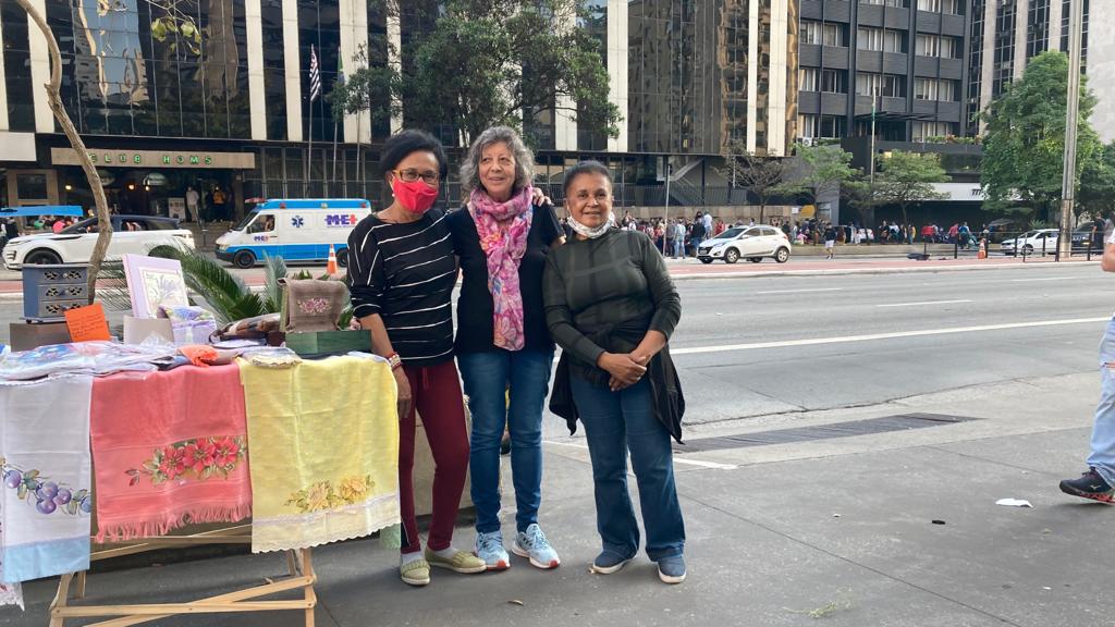 As artesãs Aparecida de Fátima, Rita das Graças e Maria Sebastiana vendendo suas produções na Avenida Paulista. 