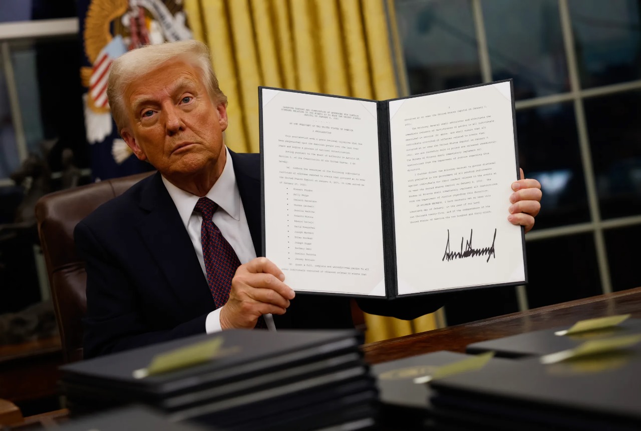 Donald Trump segurando decreto no salão oval da casa branca