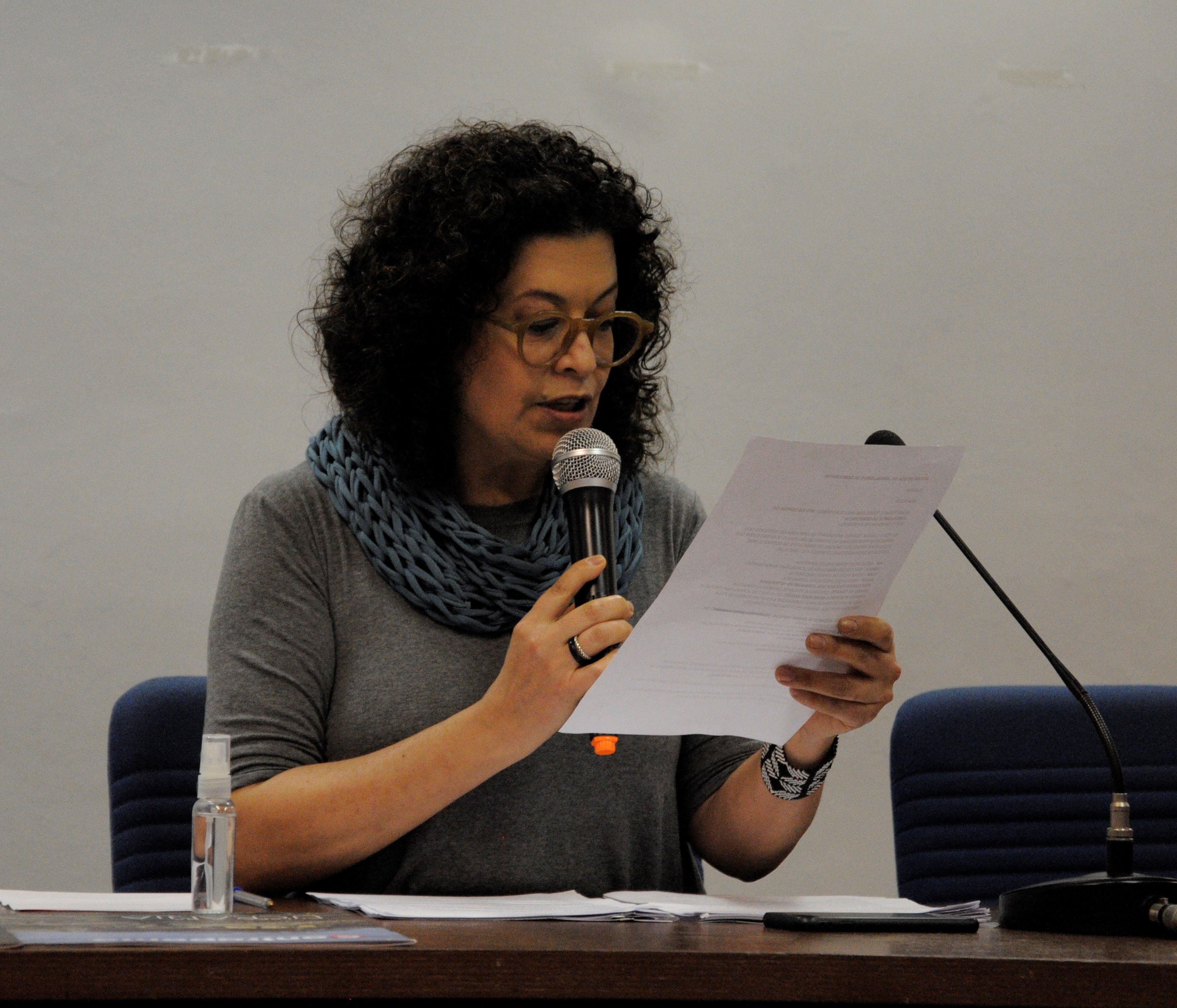A jornalista Cláudia Tavares enquanto presidia a mesa no “Ato em Defesa do Jornalismo e da Democracia” nesta terça-feira (27) na PUC-SP. Foto: Maria Ferreira dos Santos