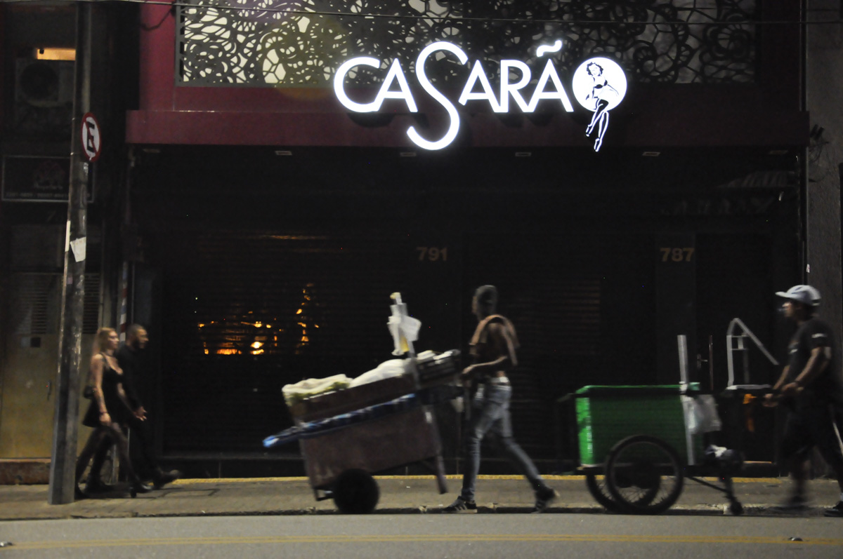 Dois vendedores ambulantes olhando o letreiro "Casarão"
