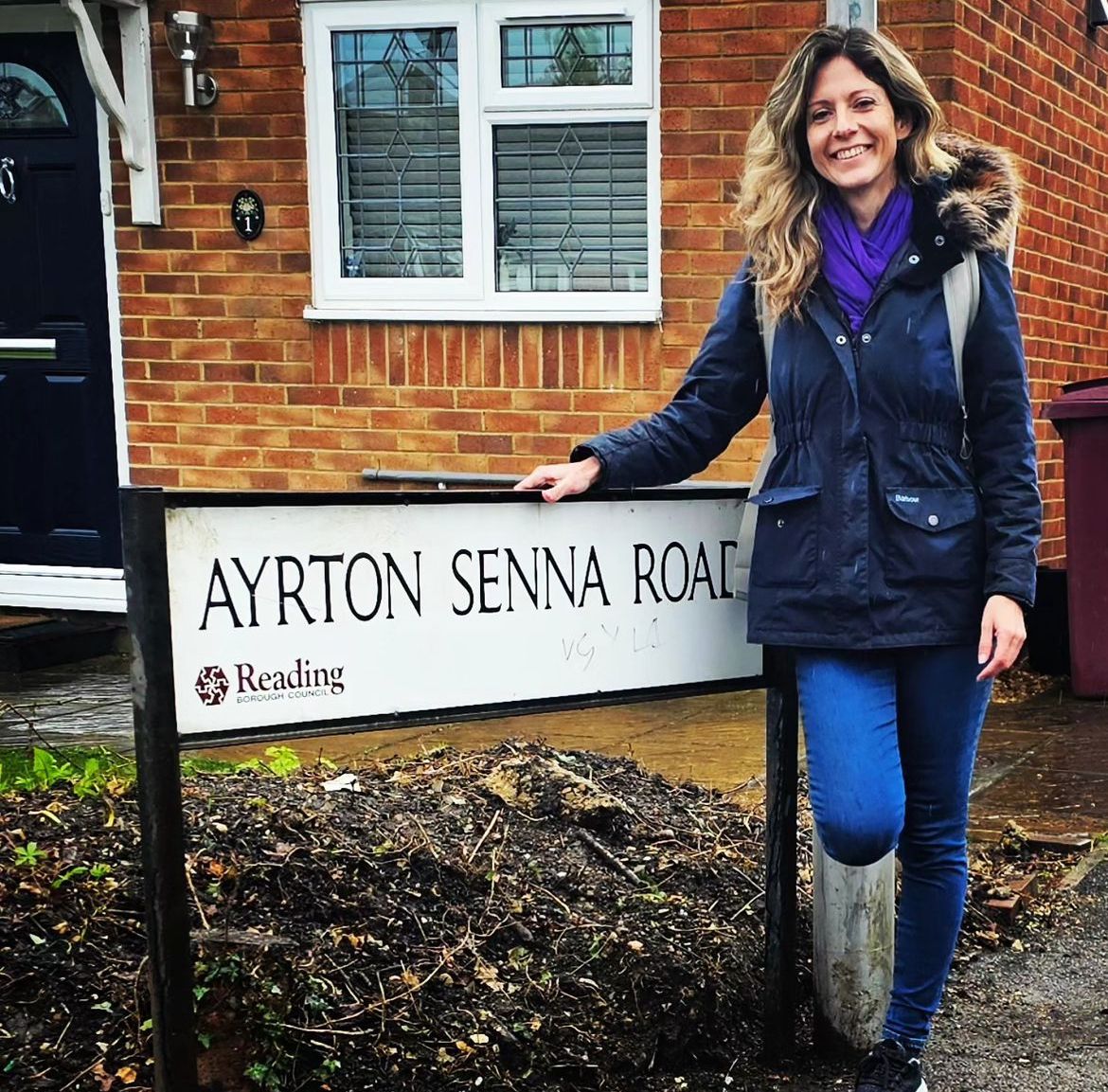 Julianne Cerasoli na frente da placa Ayrton Senna Road, na cidade inglesa de Reading. – Foto: Reprodução/Instagram @myf1life 