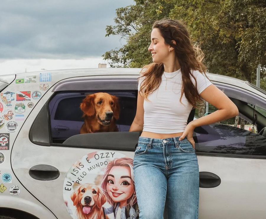 Ana Uchoa com sua cachorra Isis na frente de seu carro