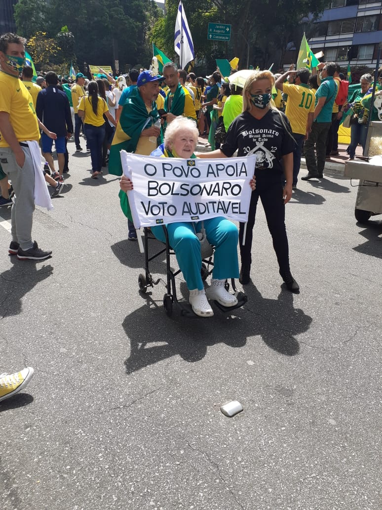 idosa segunda um cartaz escrito “o povo apoia Bolsonaro, voto auditável”