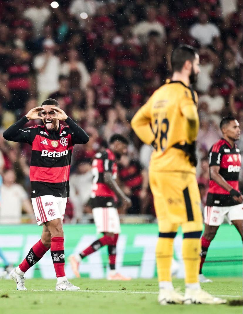 A imagem mostra à esquerda, o jogador Samuel Lino, do Flamengo, comemorando o gol simulando um binóculo. Do lado direito está o goleiro Marcelo Rangel, do Remo, de cabeça baixa. Ao fundo, desfocados, estão Emerson Royal e Alex Sandro, ambos do Flamengo.