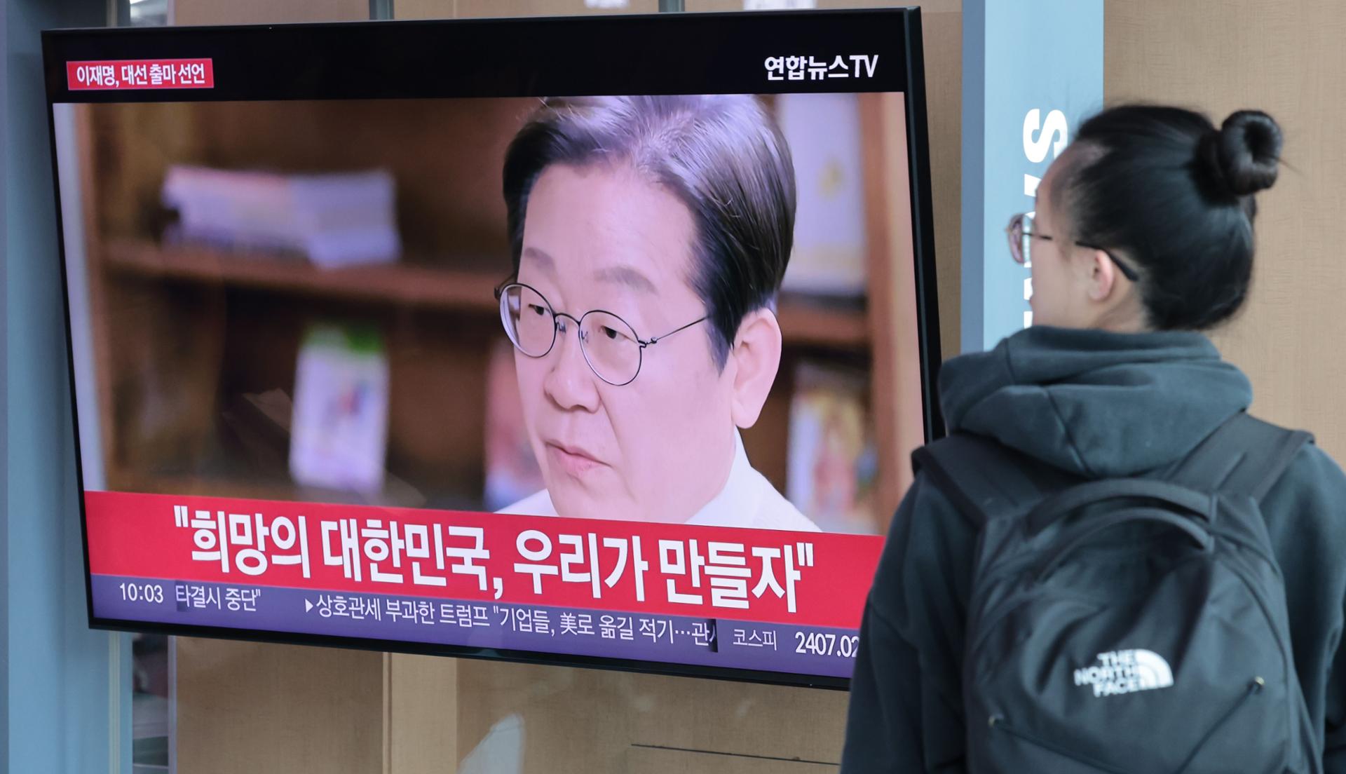 Pessoas assistem a uma mensagem em vídeo do Partido Democrata da Coreia, Lee Jae-myung, anunciando sua candidatura presidencial em uma tela de TV na Estação de Seul. Foto: The Korea Times/ Yonhap