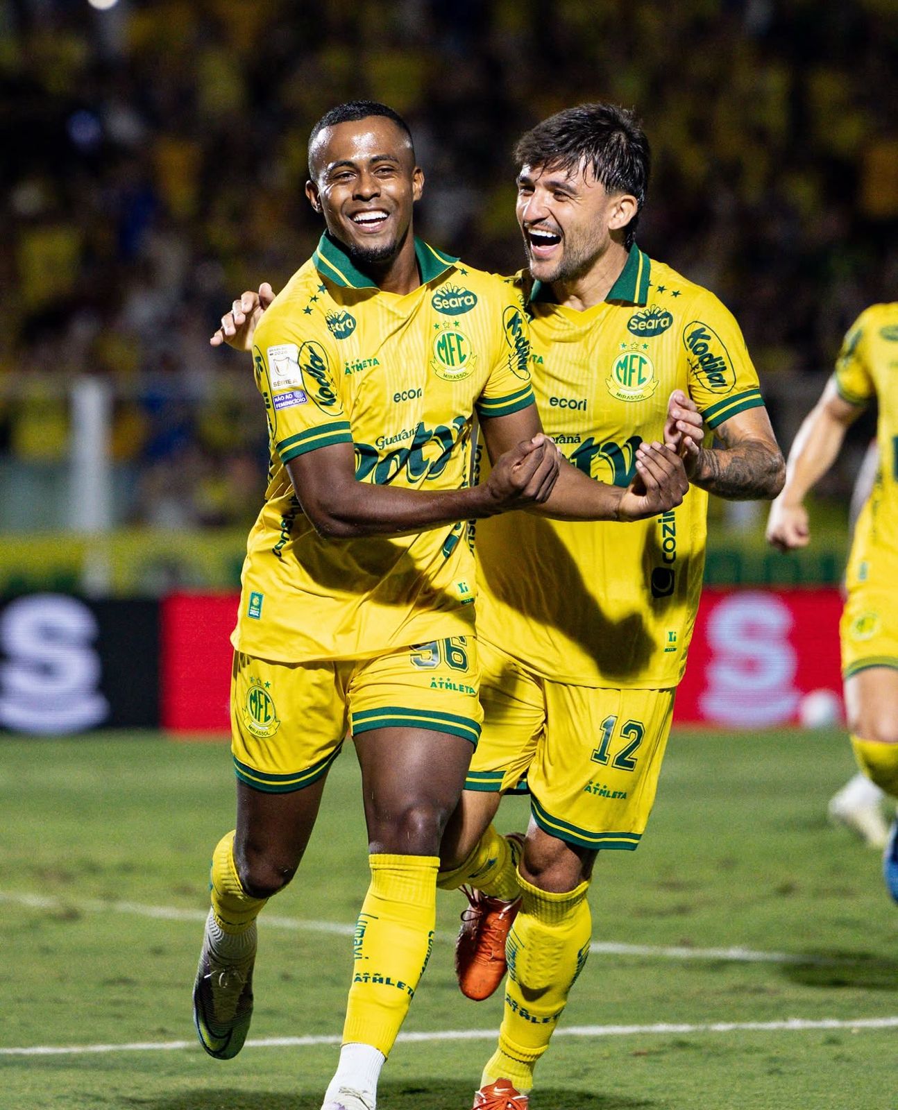 A imagem mostra Carlos Eduardo e Victor Luis, ambos do Mirassol, comemorando o gol.