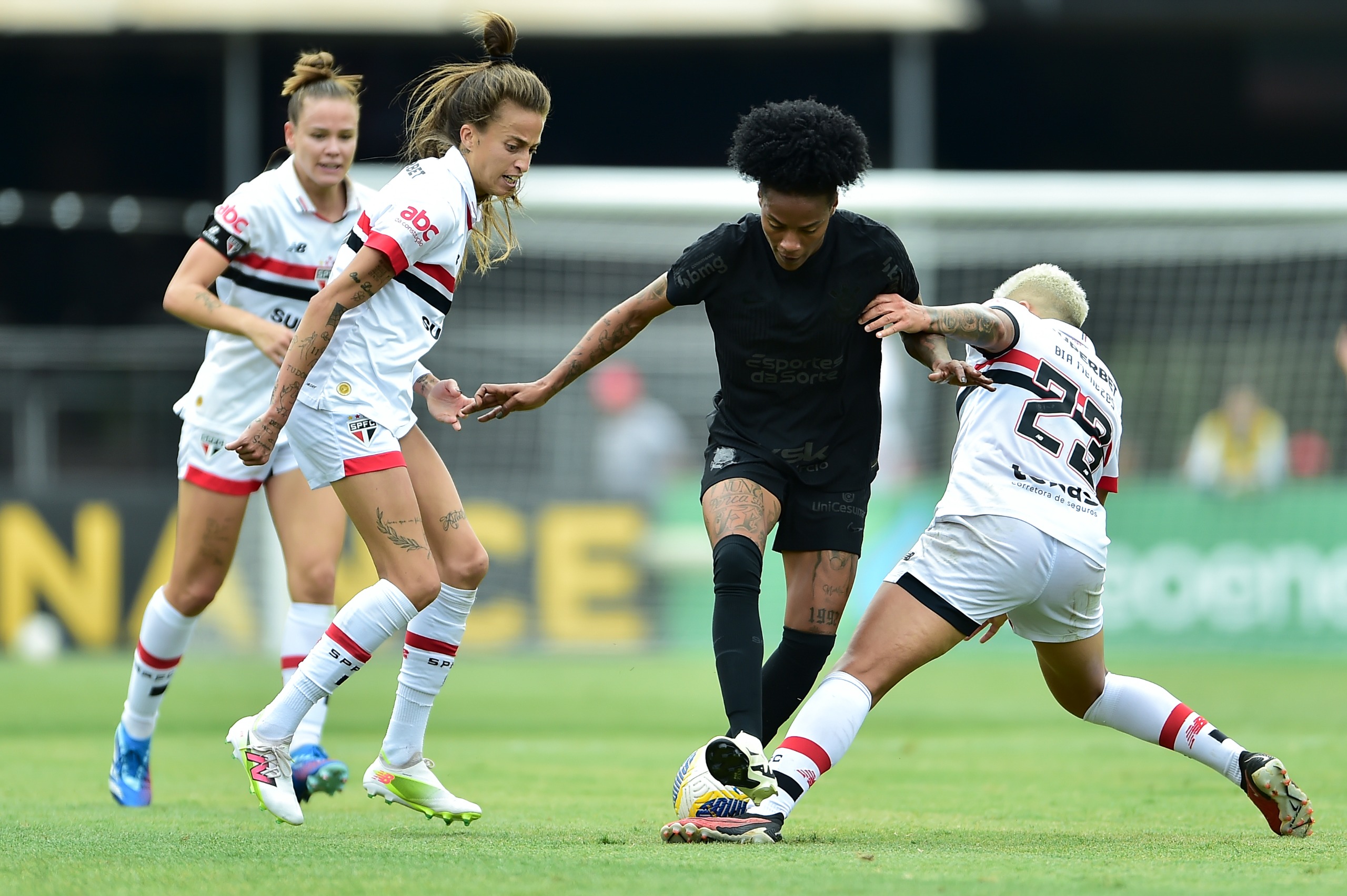 Jogadoras do São Paulo tentam roubar a bola de jogadora do Corinthians