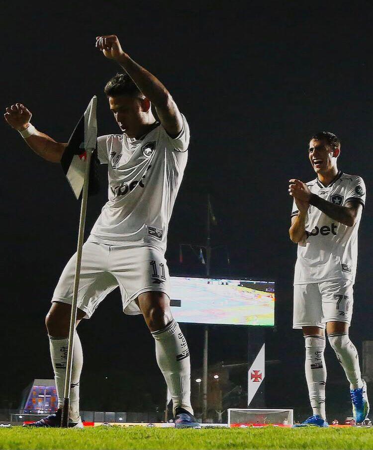 A imagem mostra jogadores do Botafogo dançando com a bandeirinha.