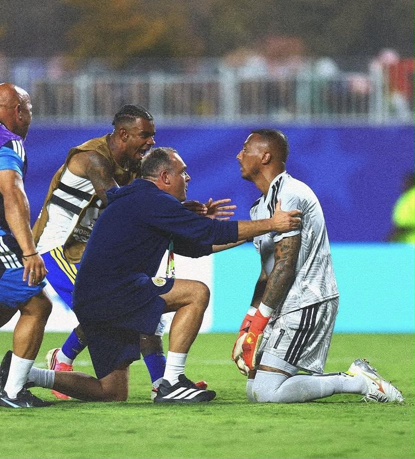A imagem mostra Eloy Room de joelhos e jogadores e comissão indo o abraça-lo