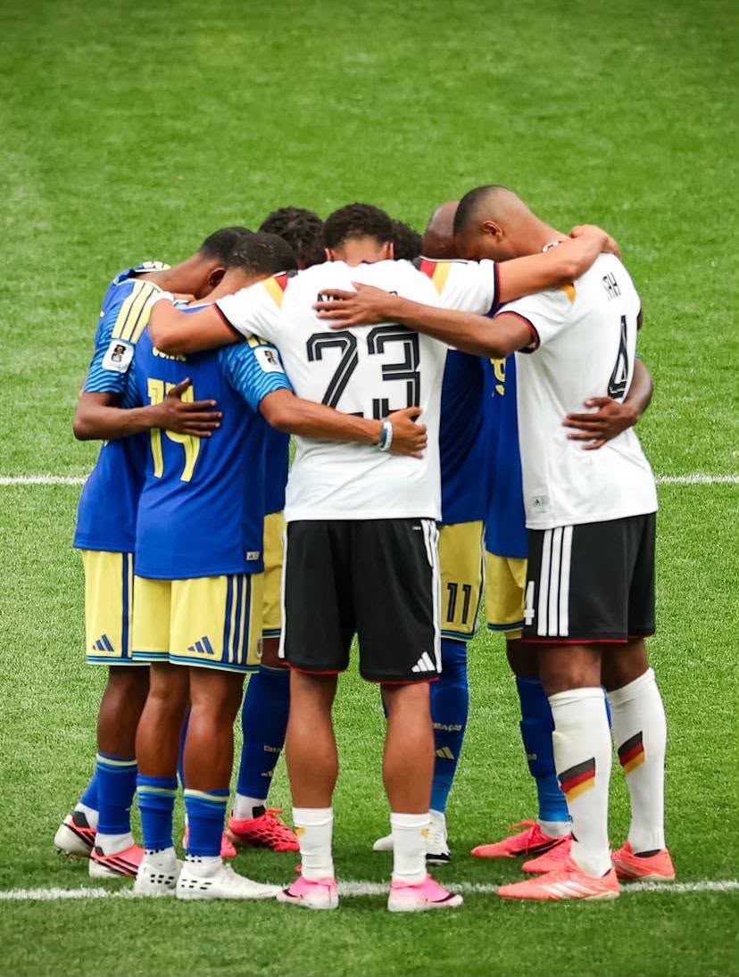 A imagem mostra jogadores de Alemanha e Curaçao abraçados no campo.