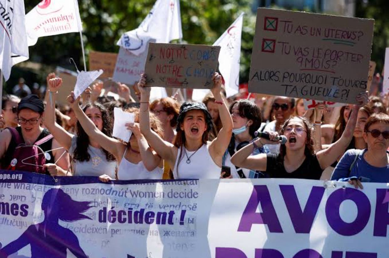 Mulheres segurando cartazes e faixas em manifestação a favor do aborto