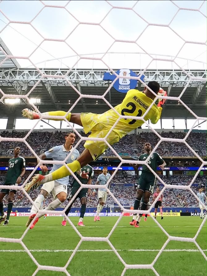A imagem mostra o goleiro da Arábia Saudita, Al-Owais, fazendo uma defesa. 