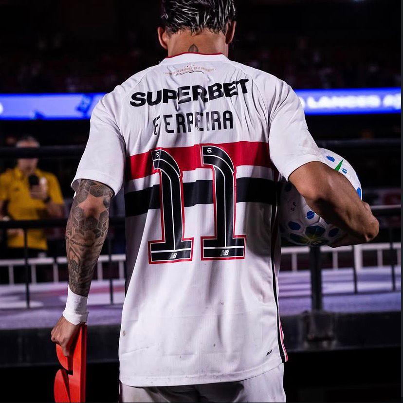 A imagem mostra o jogador Ferrerinha de costas com a bola na mão direita.