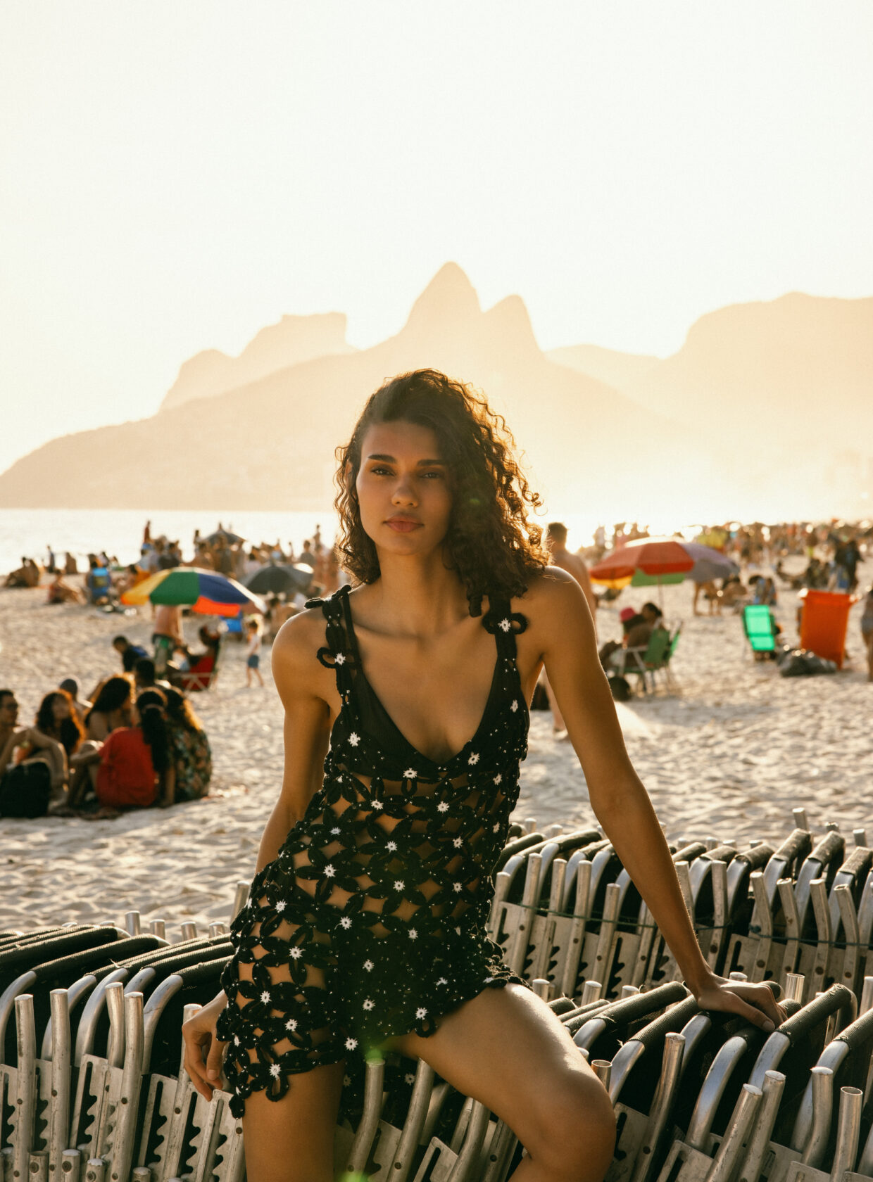 Modelo usando um vestido curto de crochê, da coleção da Zara, posando na praia do Rio de Janeiro em frente ao morro Dois Irmãos.