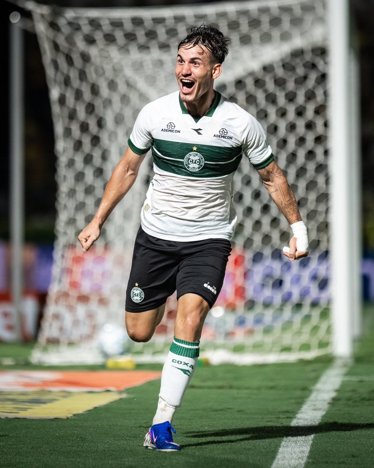 A imagem mostra o jogador Lavega comemorando uio gol. Atrás está a estrutura do gol.