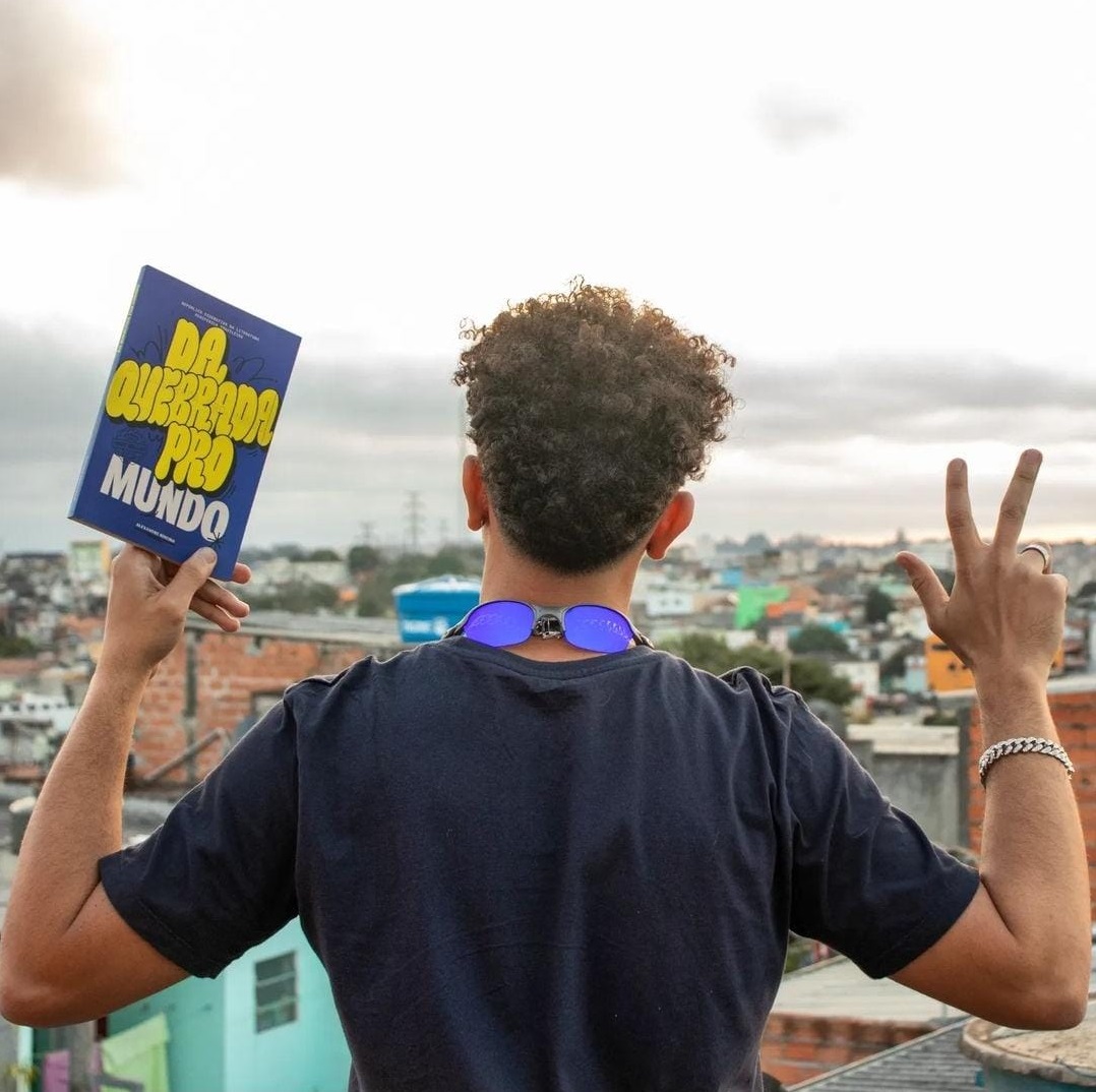 Alexandre com o seu livro na Favela das Torres, em Diadema. Divulgação: Da Quebrada Pro Mundo.