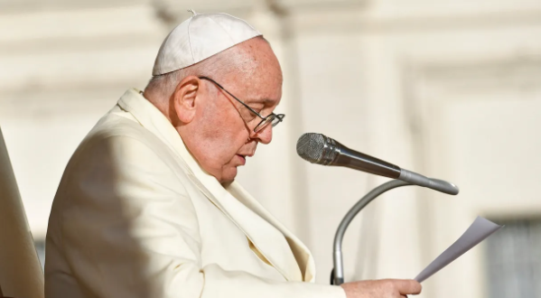 Papa Francisco lendo um texto no microfone.