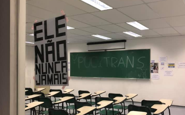 Sala de aula com cartazes em oposição às falas do professor