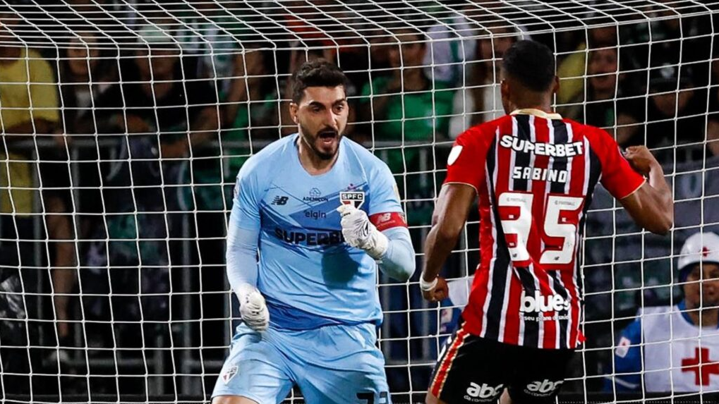 Goleiro Rafael fazendo sinal de comemoração para o jogador Sabino, ambos do São Paulo.