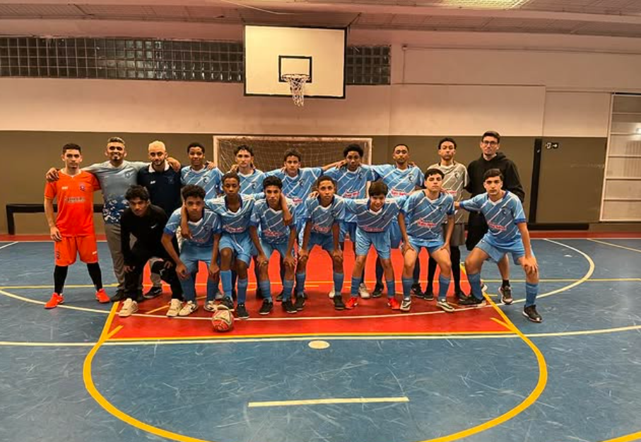 Time do Talentos da Praça, com parte em pé e parte agachados, posando para foto após jogo de futsal.