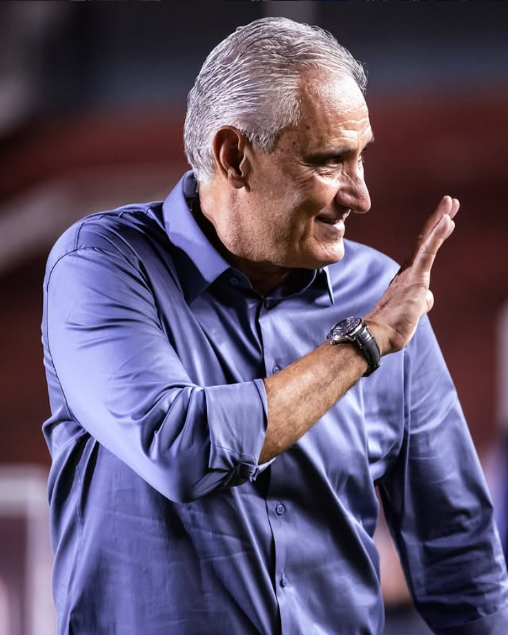 Tite acenando para o lado direito da imagem cumprimentando alguém