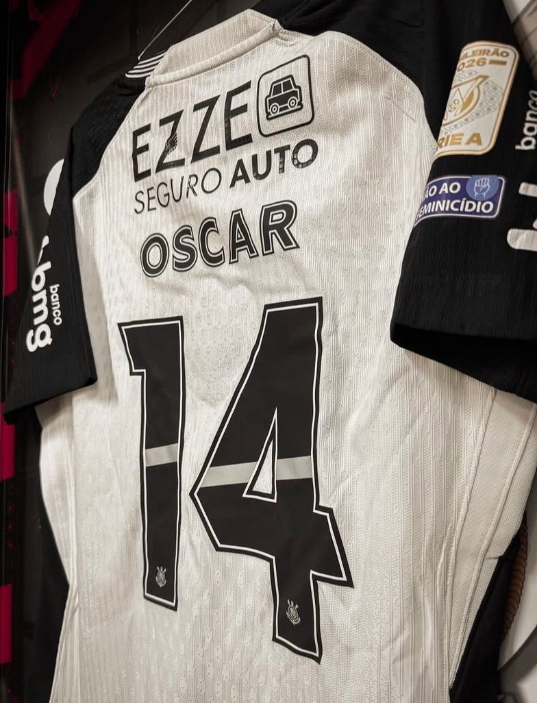 A imagem mostra uma camisa do Corinthians no vestiário. Na camisa tem o número 14 e o nome de Oscar.