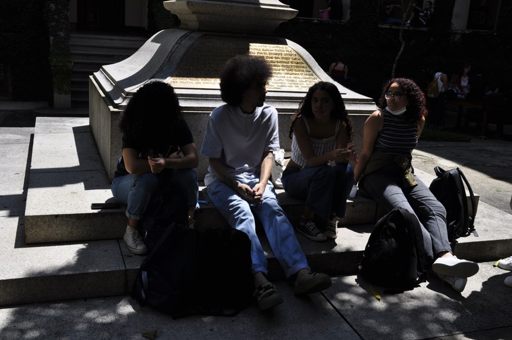 Coletivo Saravá conversando no Pátio da Cruz, na PUC-SP, à sombra do meio-dia.