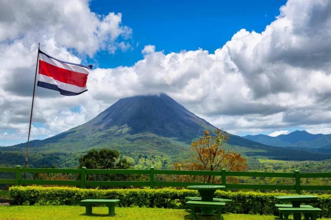 Vulcão Arenal com bandeira da Costa Rica hasteada. Reprodução: Traveloffpath