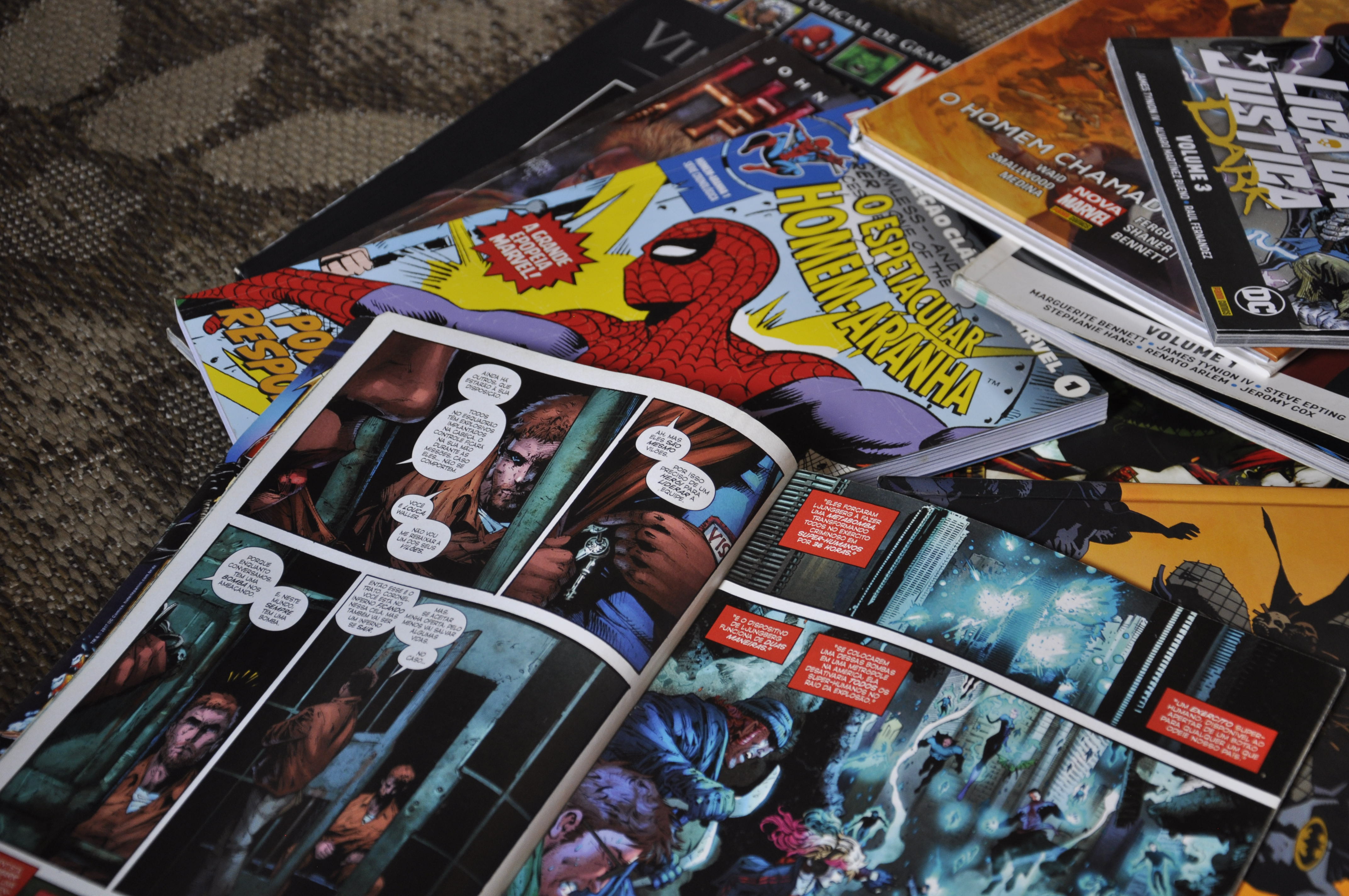 Quadrinhos de diversas editoras e heróis espalhados no chão