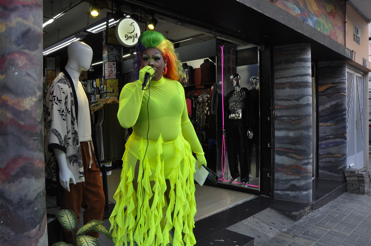 Drag Queen com uma peruca colorida e um vestido verde