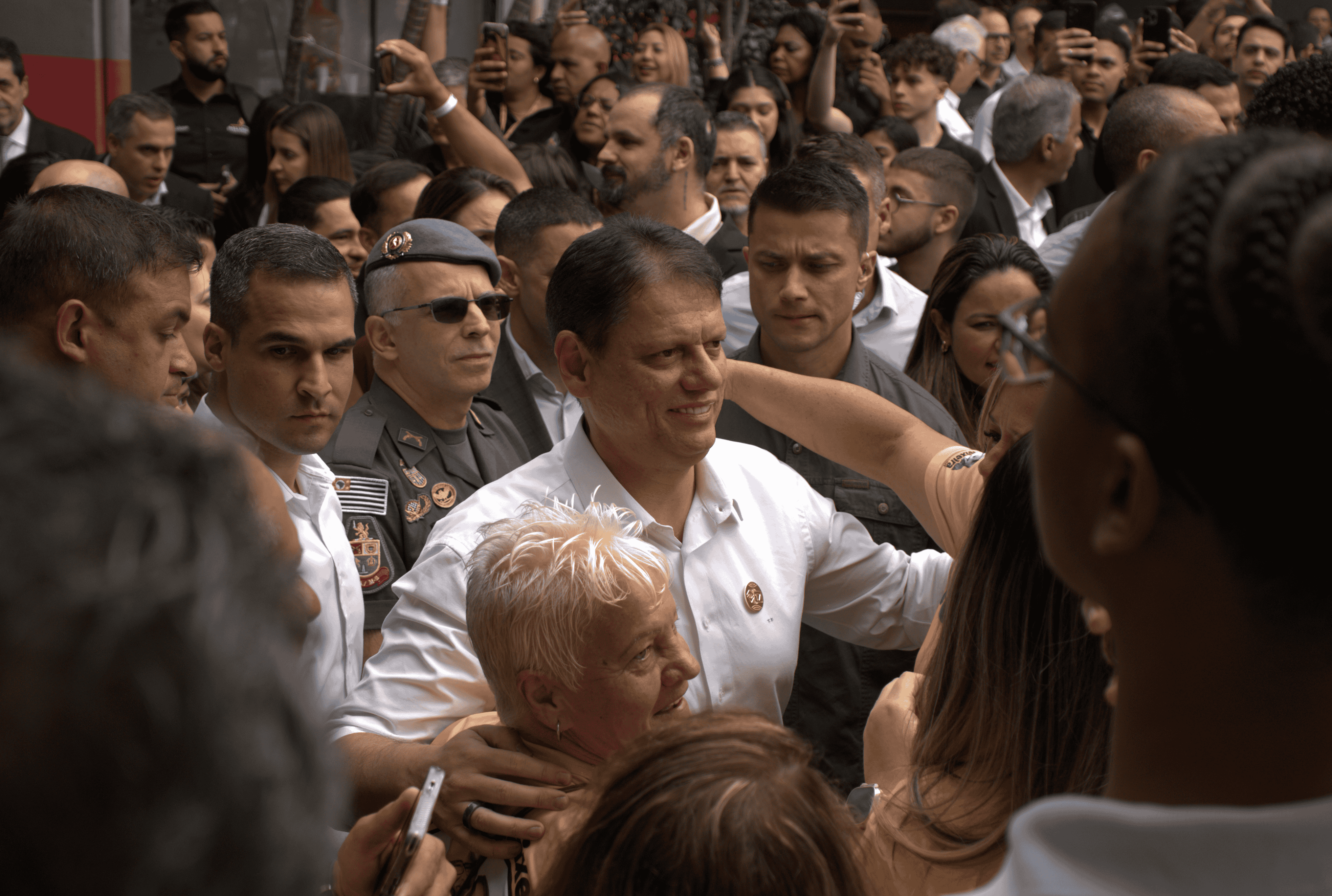 Tarcísio de Freitas cumprimentando apoiadores na entrada do evento.