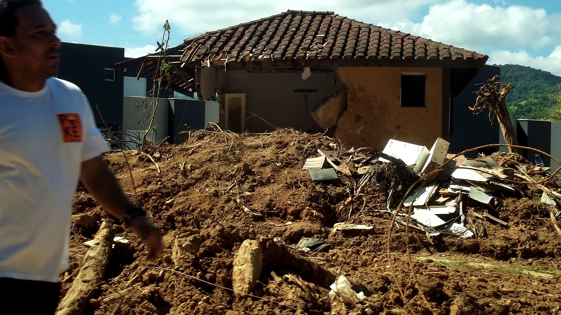 O que restou após uma casa ser destruída pelas chuvas. Ainda há móveis e um carro.