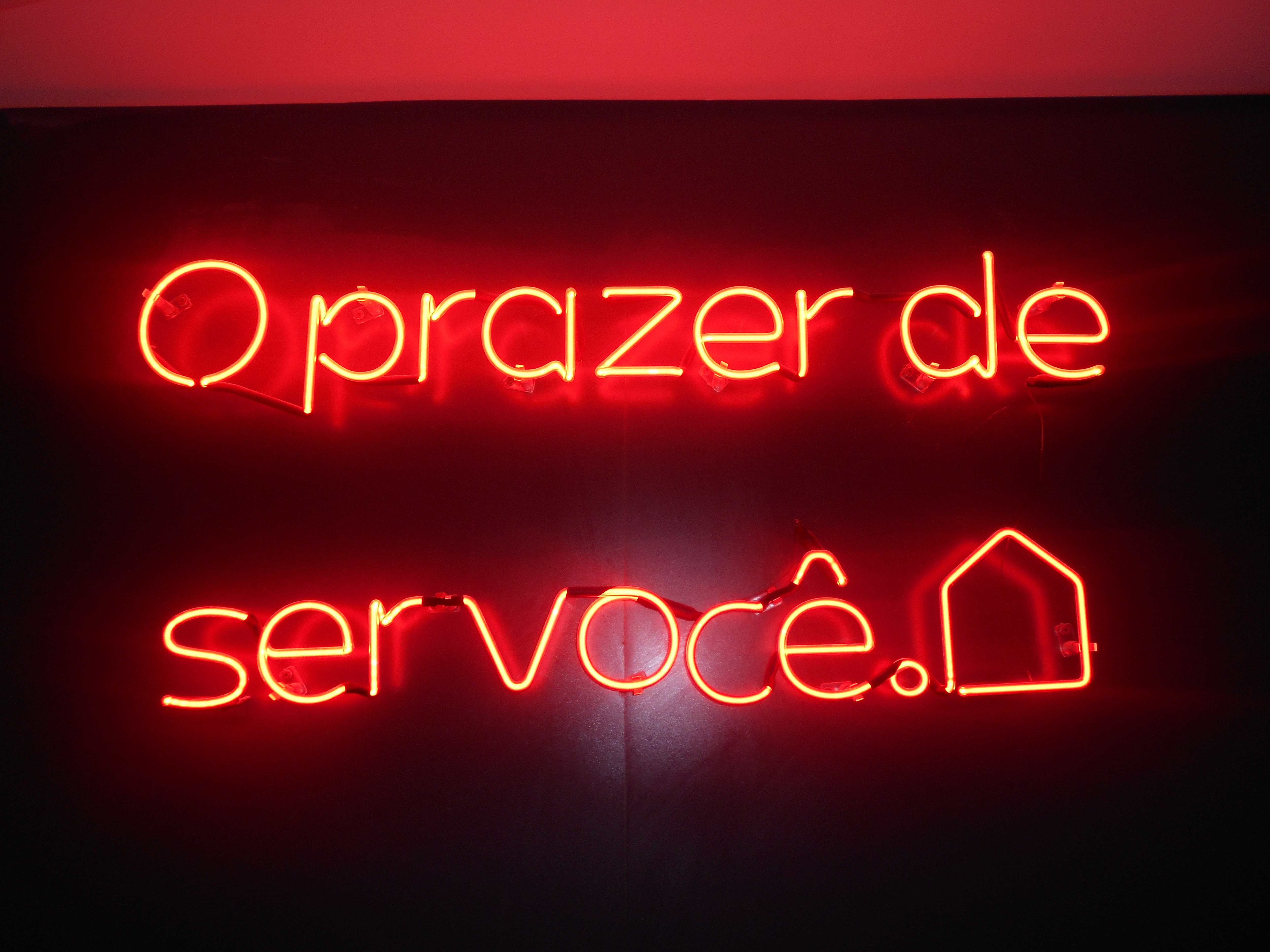 Letreiro vermelho: "O prazer de ser você".