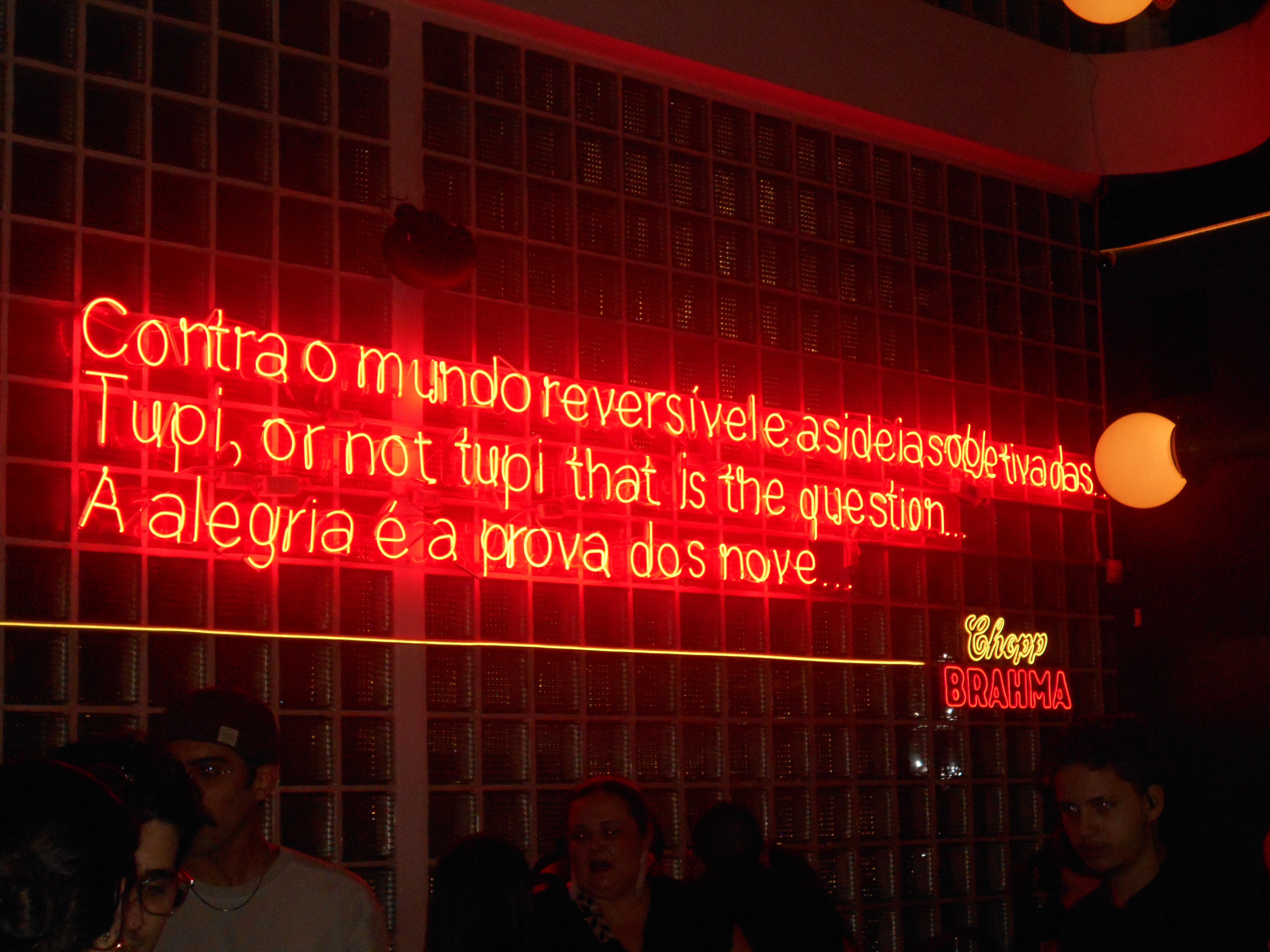 Letreiro vermelho com trecho do manifesto antropofágico.