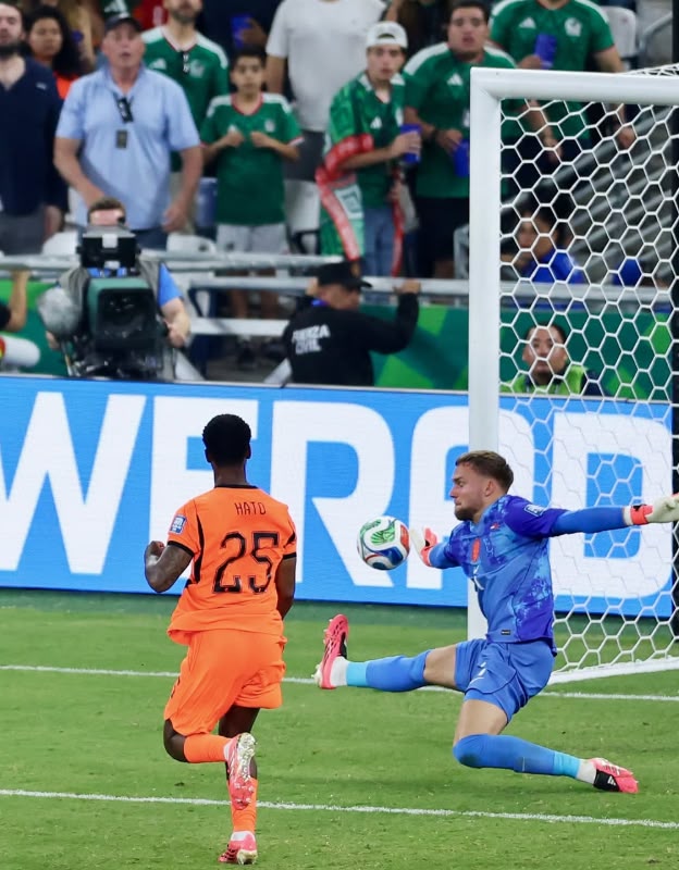 A imagem mostra Verbruggen, da Holanda, fazendo a defesa a queima a roupa no chute de Rahimi 