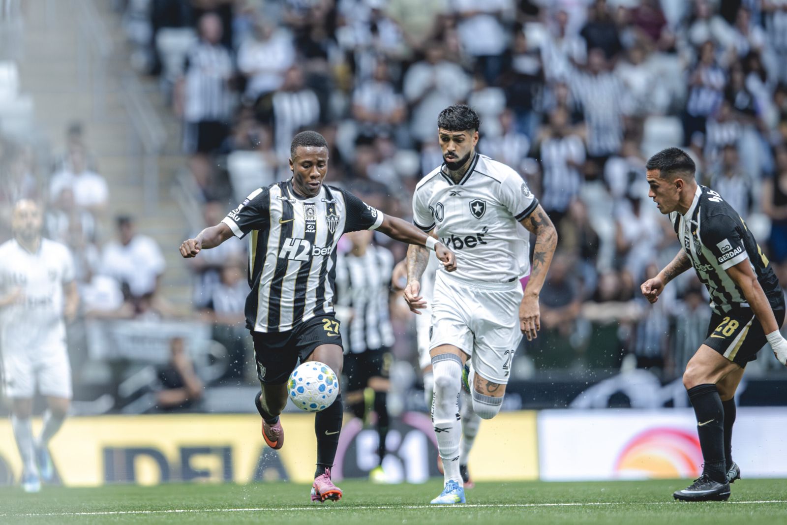 A imagem mostra Alan Minda, do Atlético-MG, e Barboza, do Botafogo, disputando bola.