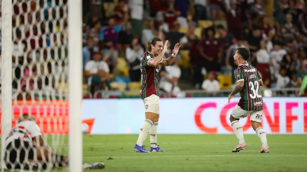 A imagem mostra jogadores do Fluminense comemorando o gol.