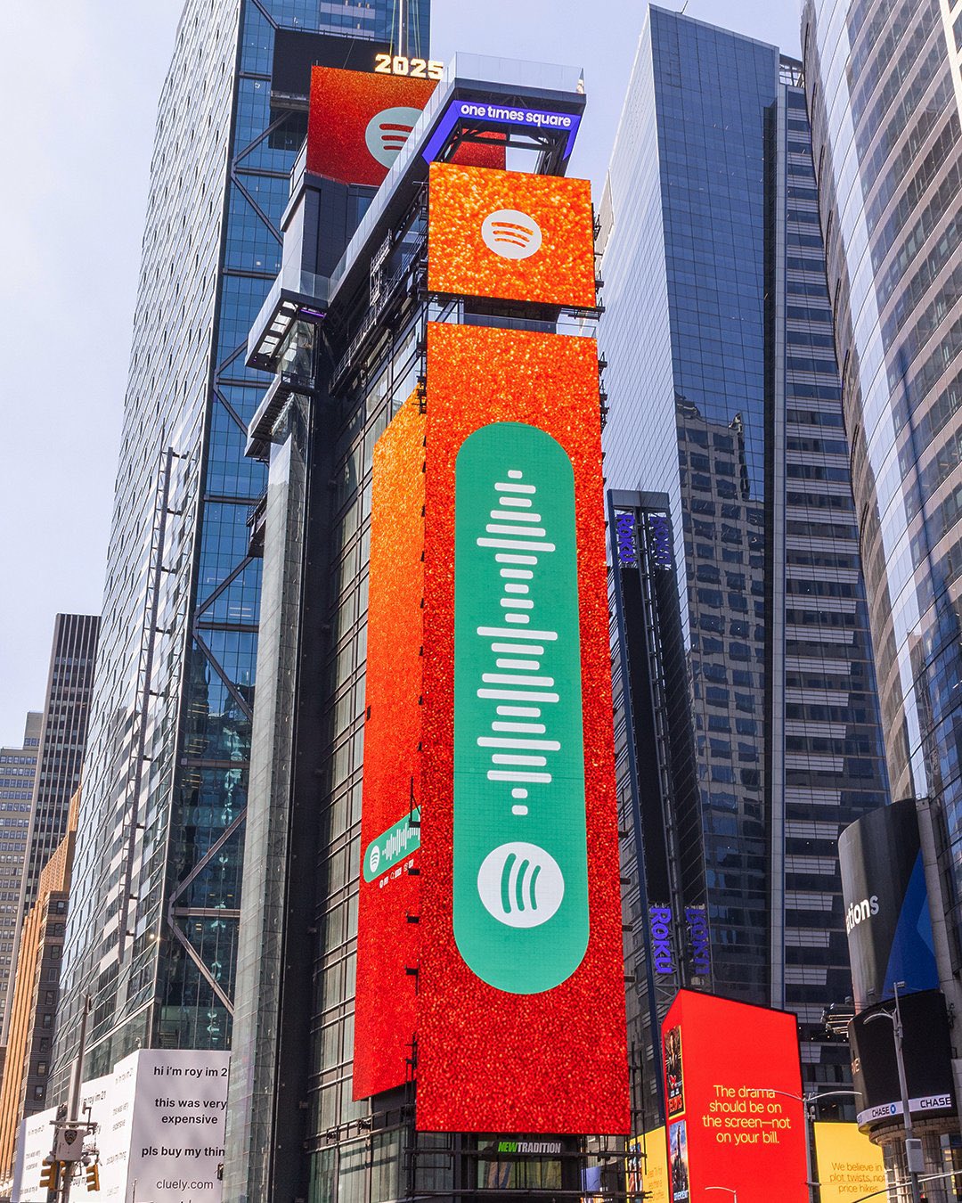 Outdoor em Nova York com fundo laranja brilhante, no centro está o código para uma playlist exclusiva da cantora Taylor Swift