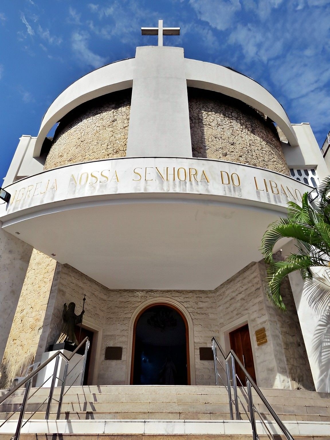 Fachada da Igreja Nossa Senhora do Líbano, com abrangência das escadas da entrada e de parte da rua em que está situada (como prédios vizinhos e sinalizações de trânsito).