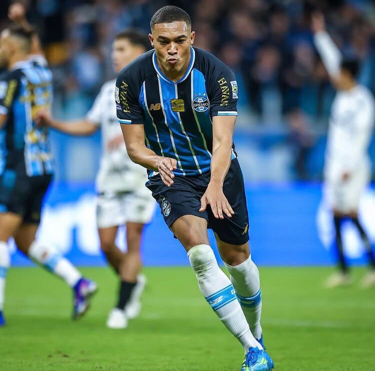 A imagem mostra Carlos Vinicius, do Grêmio, comemorando o gol.