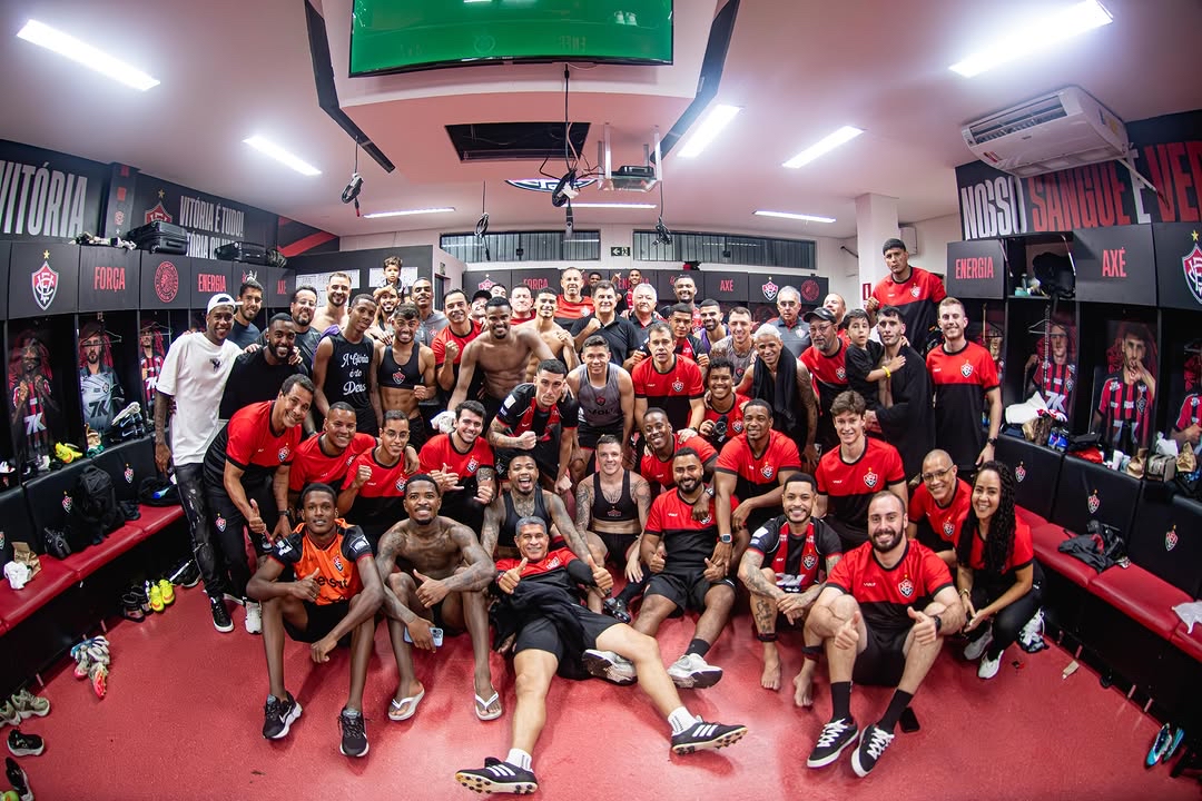 A imagem mostra o elenco do Vitoria comemorando no vestiário