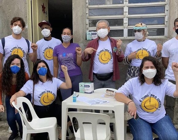 Militantes da campanha É Tudo Pra Ontem com camisetas da campanha e punhos levantados em sinal de resistência.