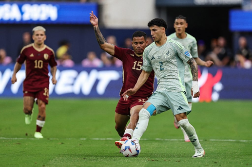 Jogadores das duas seleções disputando a bola, Venezuela de camisa vinho e México de camisa verde. (foto: Buda Mendes/AFP)