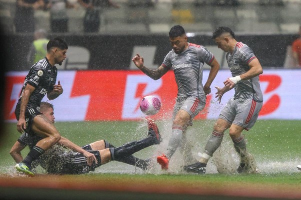 Jogadores de Internacional e Atlético MG disputam bola com forte chuva na Arena MRV