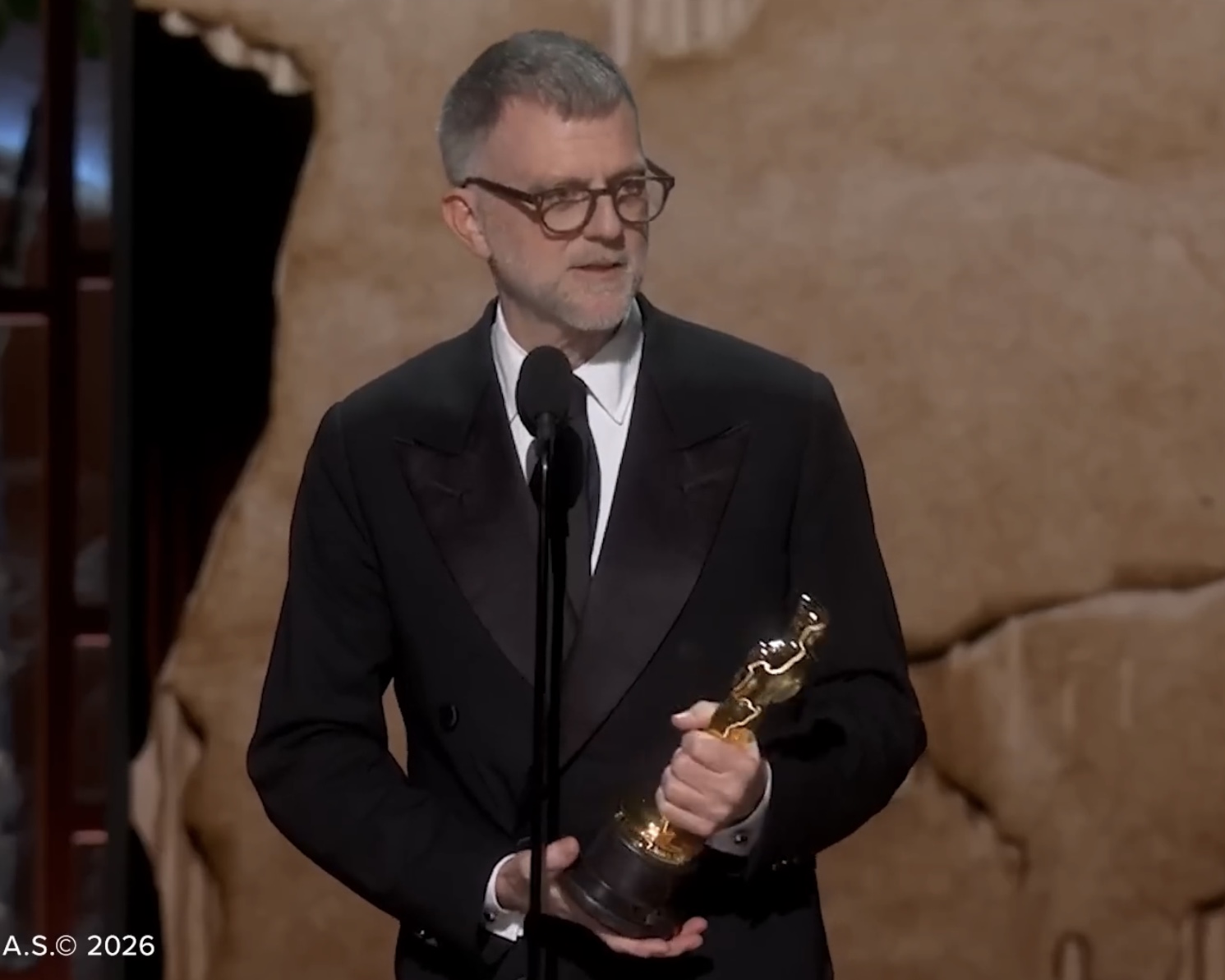 Paul Thomas Anderson, diretor de filmes estadunidense, segurando um Oscar enquanto discursa