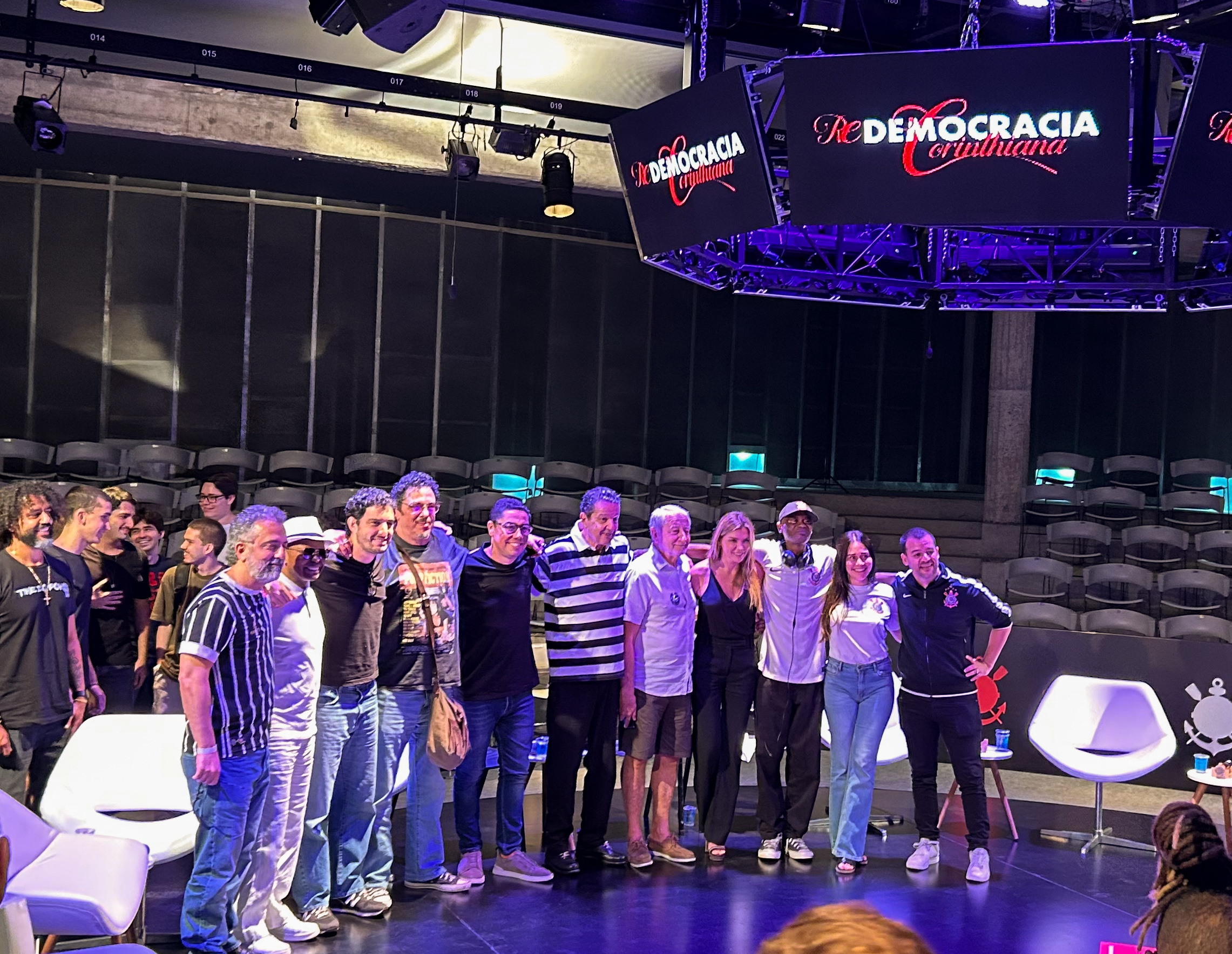 A imagem mostra, da esquerda para a direita, Homero Olivetto, Wladimir, Sócrates Jr, Walter Casagrande, Cassio Brandão, Juca Kfouri, Chico Malfitani, Marília Ruiz, Rappin Hood, Alessandra Negrini e Eco Moliterno. Todos posando para as fotos tiradas no local. 