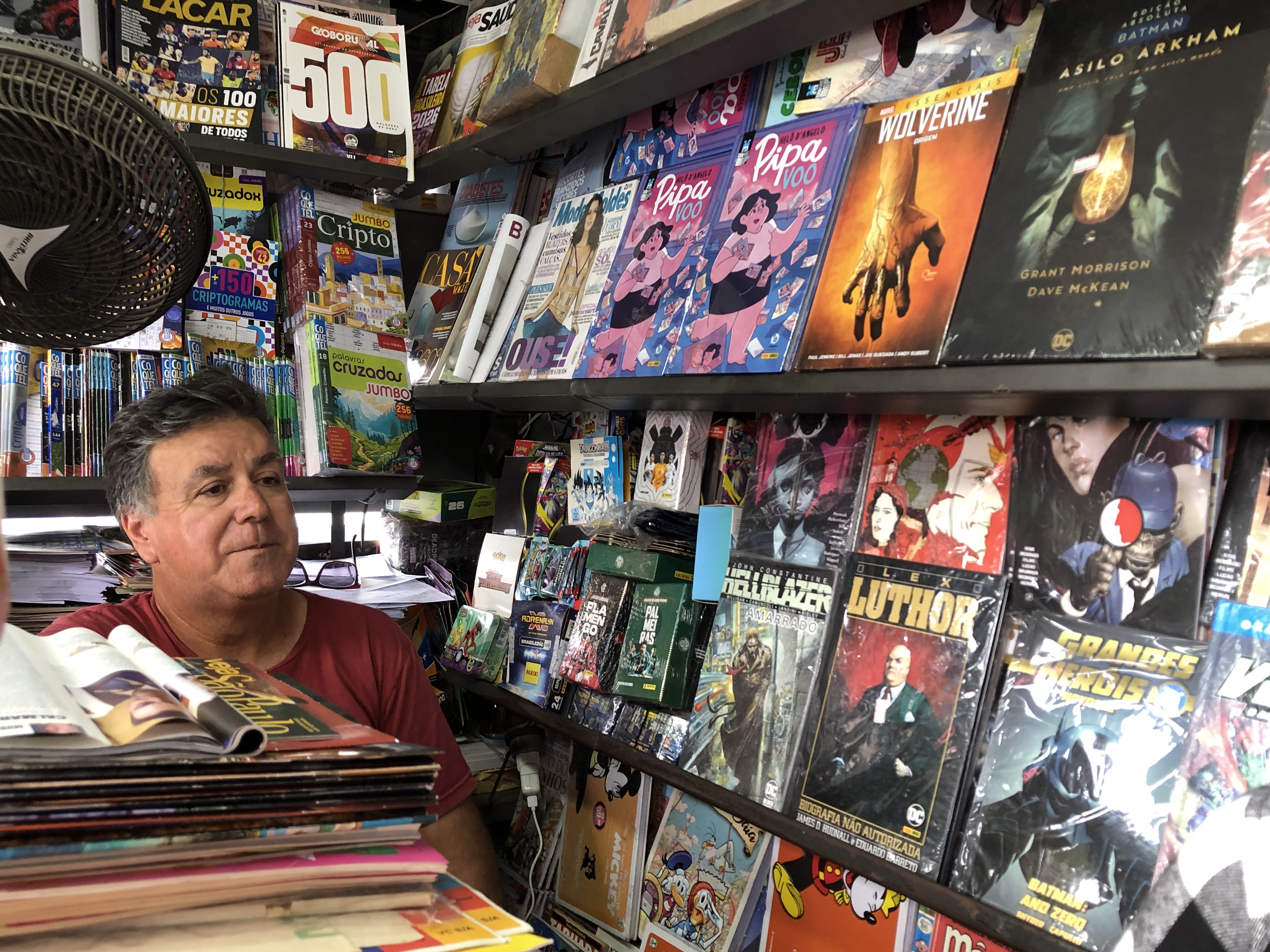 Fernando Pedroso Vaz, jornaleiro de Itapevi, ao lado de quadrinhos diversos