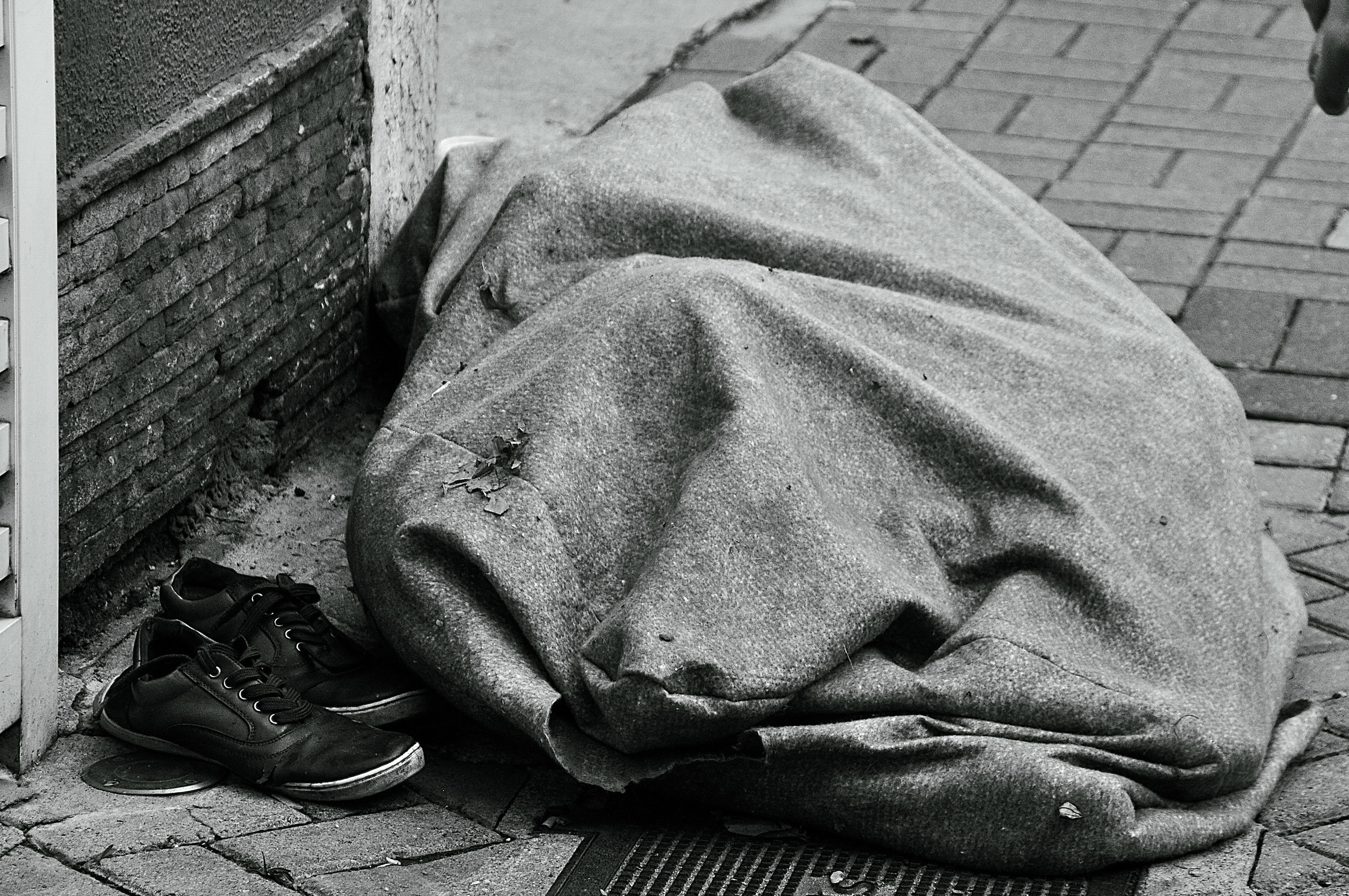 Par de sapatos e cobertor abandonados, provavelmente pertencentes a algum morador de rua. 