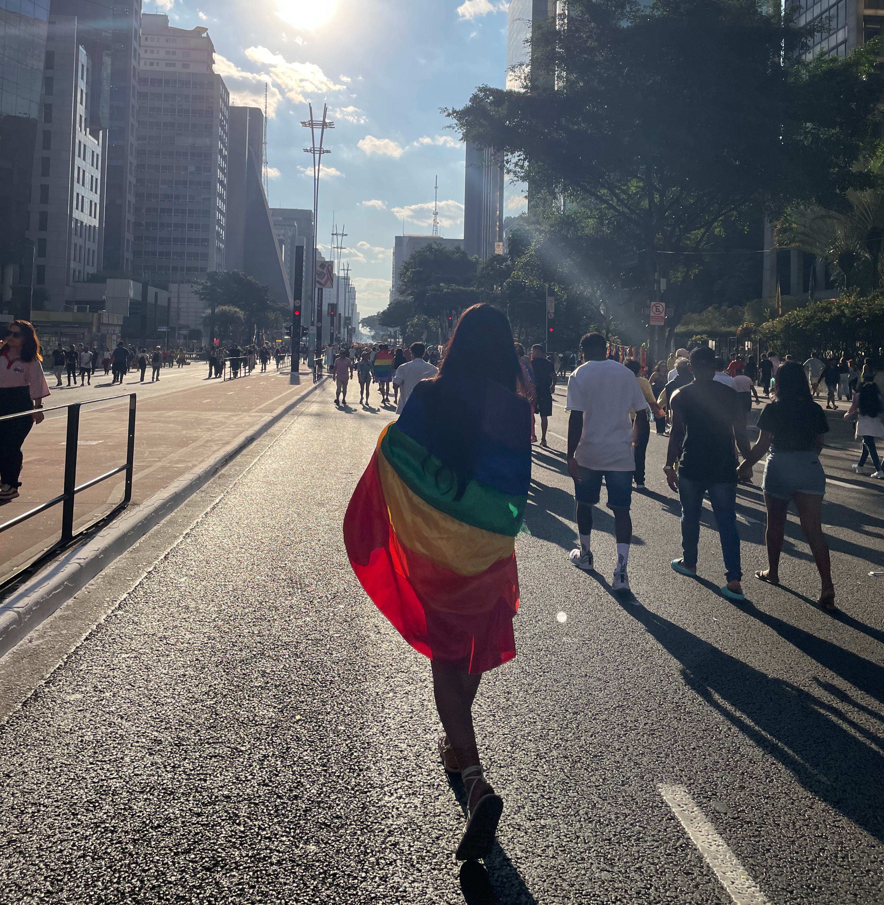 Pessoas enroladas na bandeira LGBT+ durante a Parada do Orgulho na Avenida Paulista. Foto: Juliana Bertini de Paula