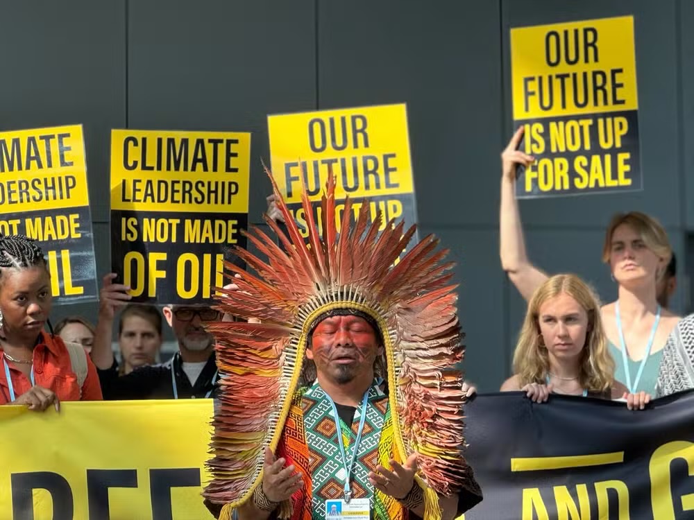 Manifestantes e Cacique Ninawá Huni Kui reunidos em Bonn, na Alemanha, para protestar contra novo leilão de óleo e gás no Brasil. Foto: Divulgação/350.org.